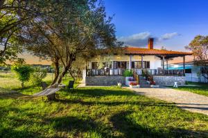 ein Haus mit einer Bank im Hof in der Unterkunft Villa Joy in Ormos Panagias