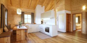 una cucina con elettrodomestici bianchi e soffitto in legno di Chalet Oberguggenberg a San Lorenzo di Sebato