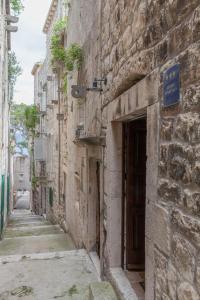 an alley in an old stone building with a door at Luxury apartment Gabriela in Korčula