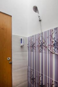 a shower in a bathroom with a shower curtain at OYO 581 Serdika Pavilion in Berastagi