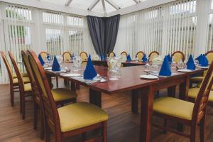 une salle de conférence avec une longue table en bois et des serviettes bleues dans l'établissement Sunninghill Hotel, à Elgin