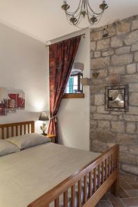 a bedroom with a bed and a stone wall at Luxury apartment Gabriela in Korčula