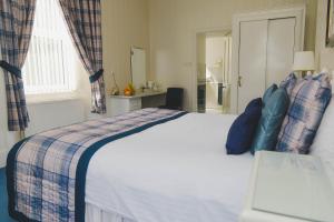a hotel room with a bed and a dresser at Sunninghill Hotel in Elgin