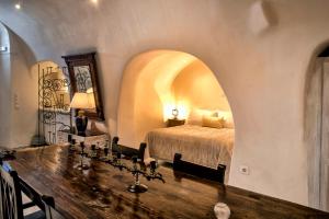 a bedroom with a bed and a wooden table at Heliophos Boutique Caves in Oia