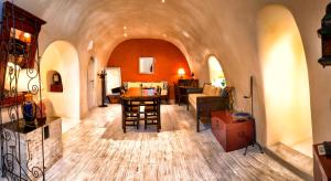 a living room with an archway with a table and chairs at Heliophos Boutique Caves in Oia