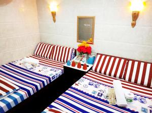 two striped beds in a room with a table and flowers at Germany Hostel Block D in Hong Kong