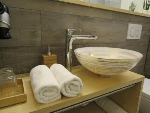 a bathroom with a sink and towels on a shelf at Hotel und Gasthof Ritter St. Georg in Erlangen +183 photos