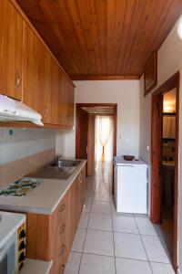 a kitchen with wooden cabinets and a white appliance at Studios Katopodi in Lefkada Town
