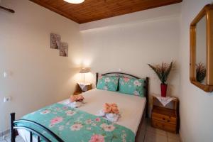 a bedroom with a bed with pink flowers on it at Studios Katopodi in Lefkada Town