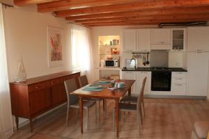 cocina y comedor con mesa de madera y sillas en Vista Lago en Maccagno Superiore