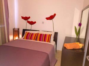 ein Schlafzimmer mit einem Bett und roten Blumen an der Wand in der Unterkunft Panorama Luxury Villa in Protaras