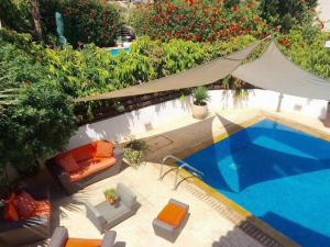 eine Draufsicht auf einen Swimmingpool mit Stühlen und einem Zelt in der Unterkunft Panorama Luxury Villa in Protaras