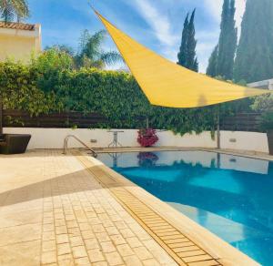 Eine gelbe Hängematte hängt über einem Schwimmbecken. in der Unterkunft Panorama Luxury Villa in Protaras + 21 Fotos