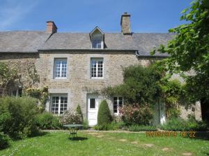 an old stone house with a table in the yard at La Haute Gilberdière in Sartilly