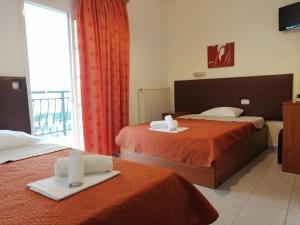 a hotel room with two beds with towels on them at Giannis Hotel in Paralia Katerinis