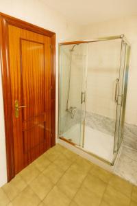 a shower with a glass door in a bathroom at La capitana Llanes in Llanes