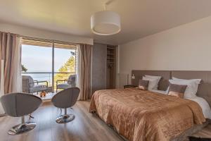 a bedroom with a bed and a large window at Domaine du Grand Bec in Villerville