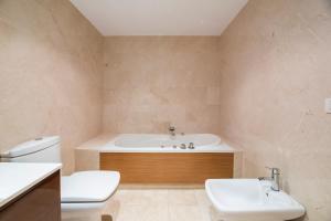 uma casa de banho com uma banheira, um WC e um lavatório. em Lanzarote Siglo XXI Sea View em Arrecife