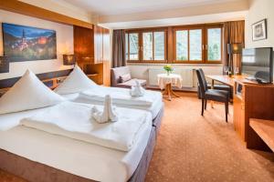 um quarto de hotel com duas camas e uma secretária em Bacharacher Hof em Bacharach