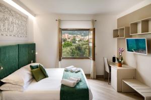 una camera da letto con letto con testiera verde e finestra di Le Muse Suite a Sorrento