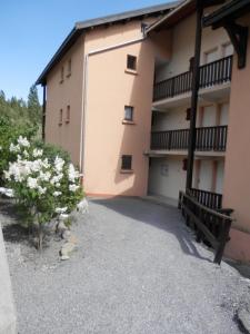 a building with a bench and flowers in front of it at L'Adroit in Barcelonnette