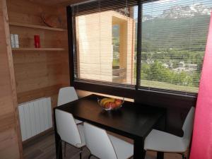 a dining room with a table and chairs and a window at L'Adroit in Barcelonnette +5 photos