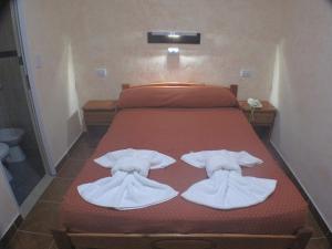 a bed with two white towels on top of it at Hotel Los Cedros in Buenos Aires