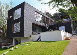 a black house with a lawn in front of it at Poolvilla in Caputh