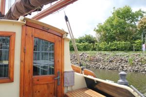 Boat and Breakfast في Strijensas: قارب مع باب خشبي على الماء