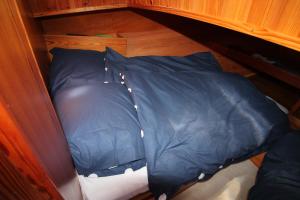 a blue sleeping bag sitting on top of a bed at Boat and Breakfast in Strijensas