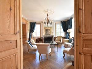 a living room filled with furniture and a chandelier at Heritage Castle in Asni res with Garden in Asnières