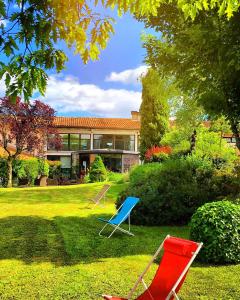 two chairs sitting in the grass in front of a house at Kyriad Angoulême Nord Champniers- Hôtel & Résidence in Champniers