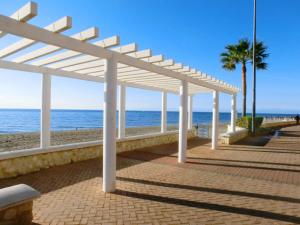 a white pavilion on a beach with the ocean at Cosy flat near the beach & town centre in Fuengirola