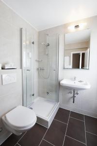e bagno con doccia, servizi igienici e lavandino. di Hotel Neufeld a Zurigo