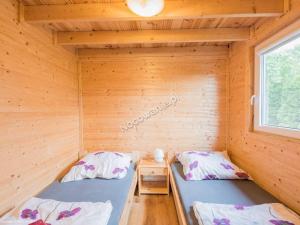 a room with two beds in a wooden cabin at Domki Letniskowe Nad Morzem in Międzyzdroje