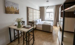 Letna Garden Suites في براغ: غرفة في الفندق بها سرير وطاولة بها زهور