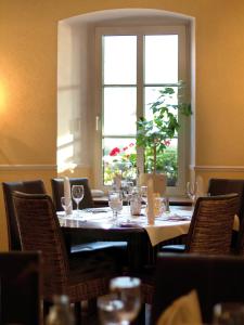 einen Tisch in einem Restaurant mit einem Fenster und Stühlen in der Unterkunft Landhotel Steffen in Lieser