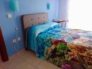 een slaapkamer met een bed met een dekbed met een oceaanthema bij Ester's Sea Side apartment in Neoi Epivatai