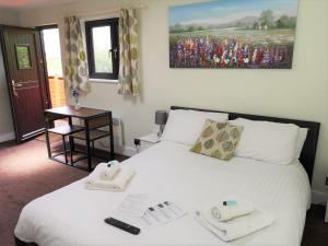 a bedroom with a bed with towels on it at Chalet Cottages in Streatley