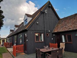 a black house with a table in front of it at Chalet Cottages in Streatley