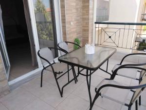 une table et des chaises assises sur une terrasse couverte dans l'établissement Ester's Sea Side apartment, à Néoi Epivátai
