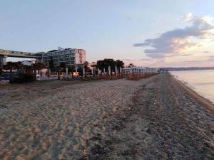 a sandy beach with umbrellas and buildings on it at Ester's Sea Side apartment in Neoi Epivates