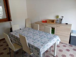 uma sala de jantar com mesa e cadeiras e uma cozinha em A casa di Luca em Lido Conchiglia