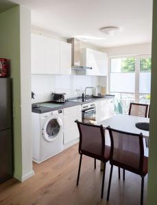 eine Küche mit einer Waschmaschine, einem Tisch und Stühlen in der Unterkunft Modernes 2-RoomApartment in Wuppertal