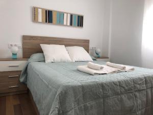 een slaapkamer met een bed met twee handdoeken erop bij RG apartamentos in Almería