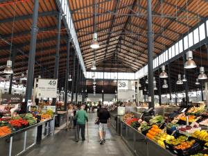 a group of people walking through a market with fruits and vegetables at RG apartamentos in Almería