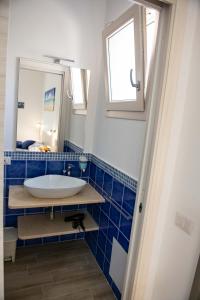 uma casa de banho com um lavatório e um espelho em B&B Il Viaggiatore em Tortolì