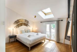 - une chambre avec un lit blanc et une lucarne dans l'établissement CMG Porte d'Orléans - Montrouge, à Montrouge