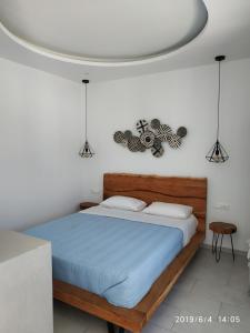 a bedroom with a bed with a blue comforter at Nikos Rooms in Vrisi/ Mykonos