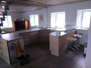 a large kitchen with wooden floors and white cabinets at Jurahaus Maisonette Wohnung in Solnhofen